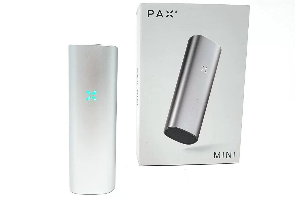 Silver Pax Mini vaporizer next to the box it comes in