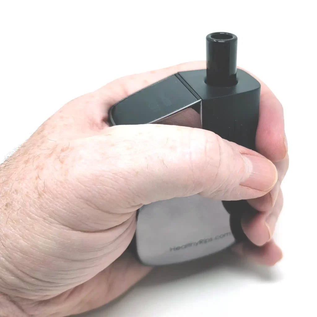 The Rogue 2 in the palm of a man's hand to show the compact size of the vaporizer.