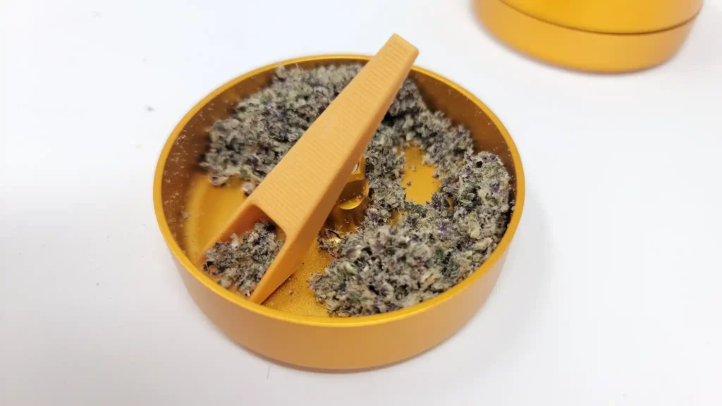The grind consistency of the Odin threadless grinder, displayed with its weed scoop