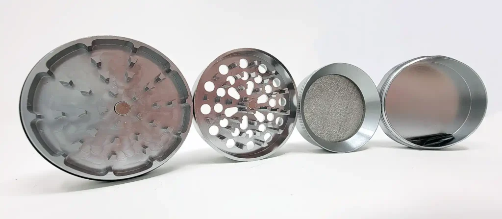 Four pieces of the Healthy Rips SHRED weed grinder lined up and balanced on their edges