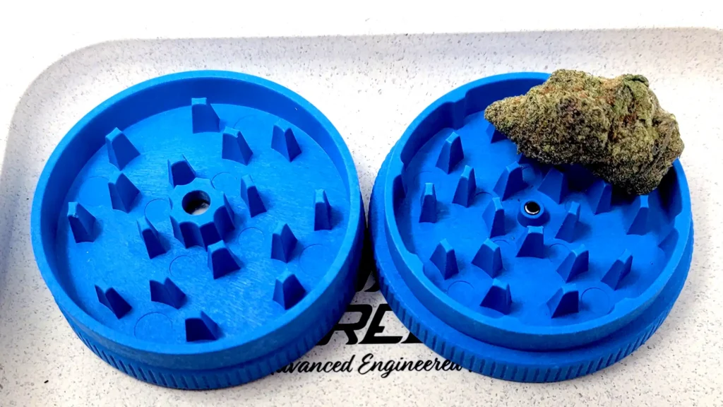 Hemp 2 piece grinder shows its exposed teeth with a nug ready to grind
