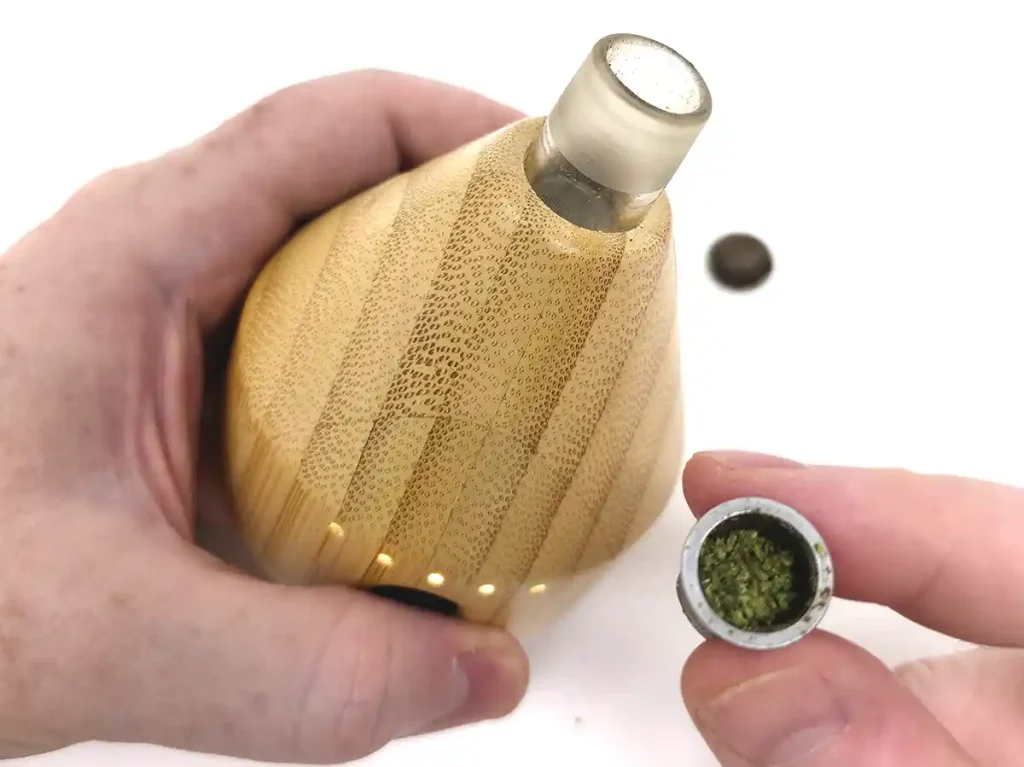 Camouflet Fuji vaporizer in hand with its bowl removed and visibly filled